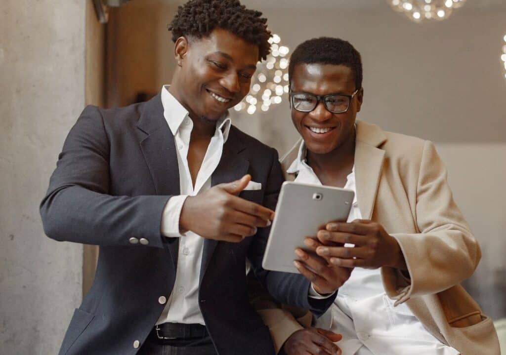 Two black men sharing a tablet screen